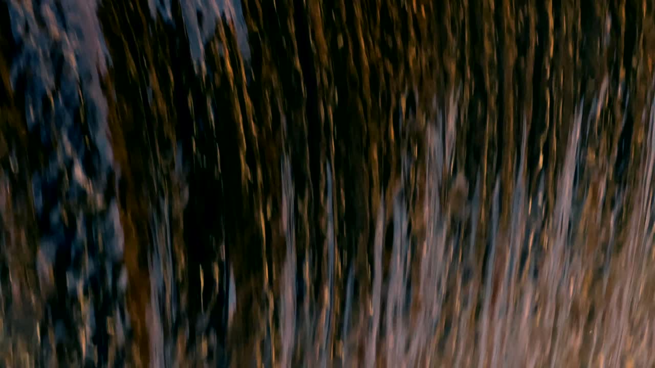 Polluted water waterfall flow slomo black murky stream magnetic fall matrix downward into foamy mix