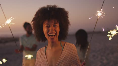 mixed race woman playing with fire on the beach