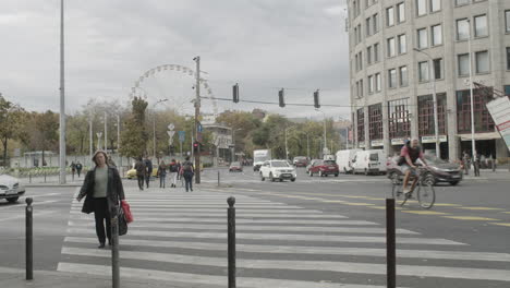 a young woman using her phone approaching a crosswalk, waiting to cross bajcsy zsilinszky road in the city of budapest.