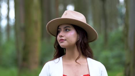 woman looks thoughtfully around the landscape, then looks into the shot and begins to smile