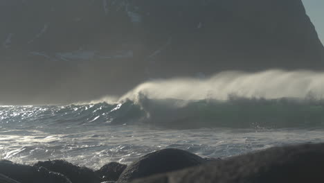 波浪在unstad海<unk>上慢慢地打破,背景是一座崎<unk>的山