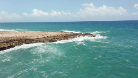 Aerial-scenic-revealing-view-stormy-caribbean-shore-with-crashing-waves-and-beautiful-nature