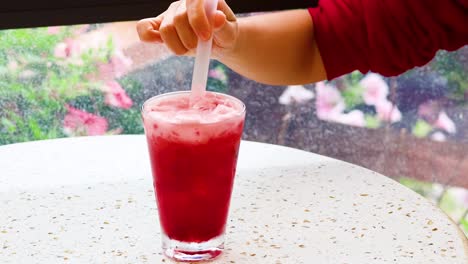 persona agitando y bebiendo jugo de sandía