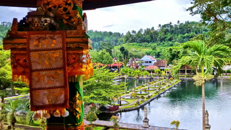 traditional balinese shrine with colorful offerings, lush green landscape in tirta gangga