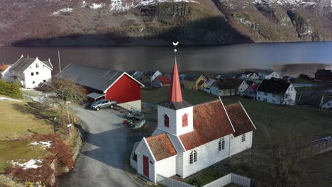 ancient stave church of undredal along aurlandsfjord in norway - aerial showing europes smallest stavechurch during sunrise