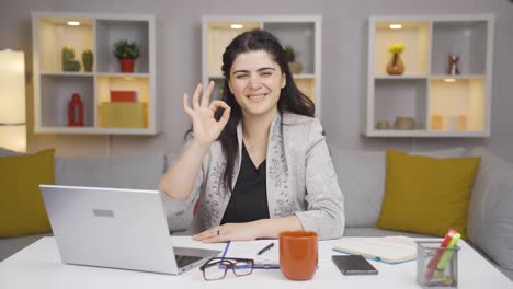 mujer trabajadora de oficina en casa haciendo un gesto positivo a la cámara.