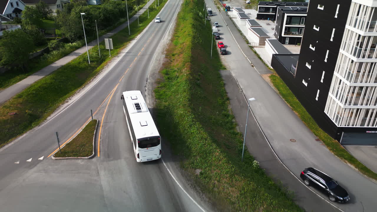 autobús blanco conduce a través de la rotonda en el vecindario de tromso, seguimiento aéreo