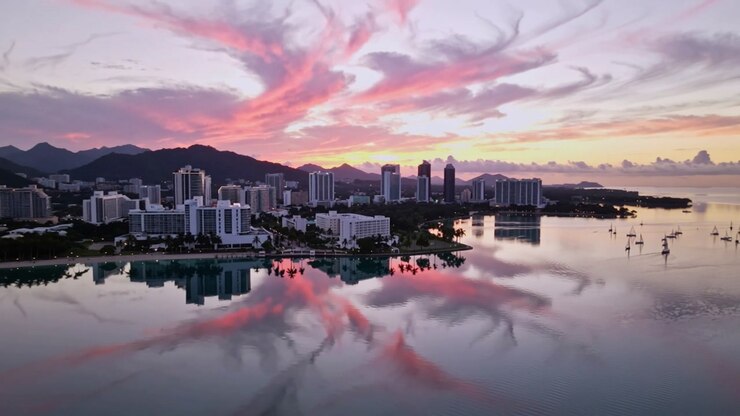 Camera gliding forward at dusk, revealing coastal skyline for travel marketing with mirrored clouds