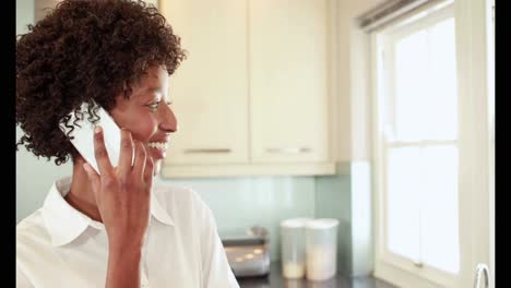 Mujer-Feliz-En-Su-Cocina-Hablando-Por-Teléfono