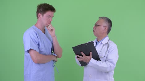 studio shot of doctor and patient talking against green background