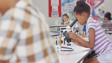 video of happy african american girl with microscope during lesson