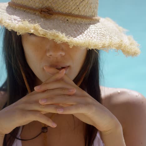 exotic brunette wearing straw hat while in pool