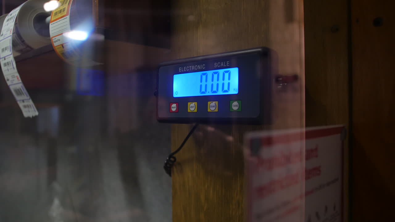 Weighing a parcel package on electronic scales at a post office