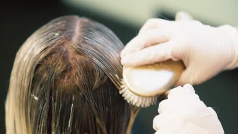 woman having hair color applied to hair to lighten and make more stylish