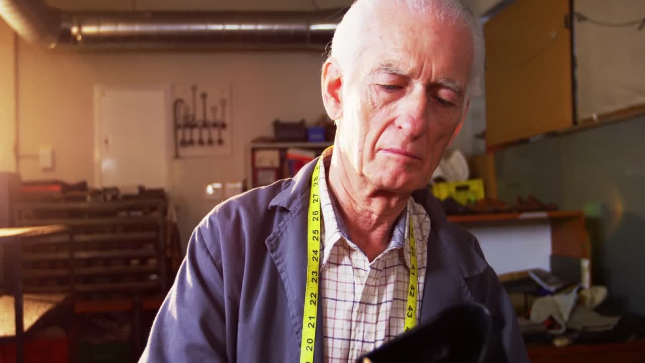 신발 제작자 가 신발 을 검사 하고 있다