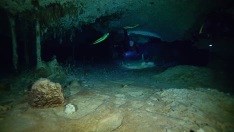 divers swim through a tight tunnel off the coast of mexico's yucatan peninsula