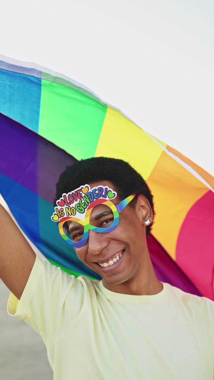 Happy Young Person Smiling with Rainbow Pride Flag and Glasses