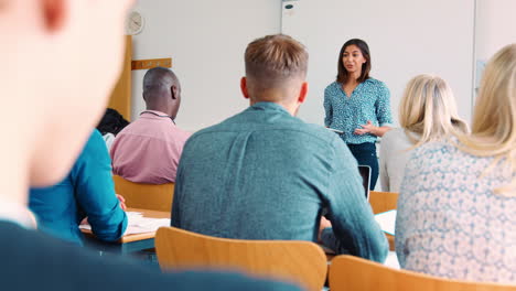 female college tutor with digital tablet teaches mature students