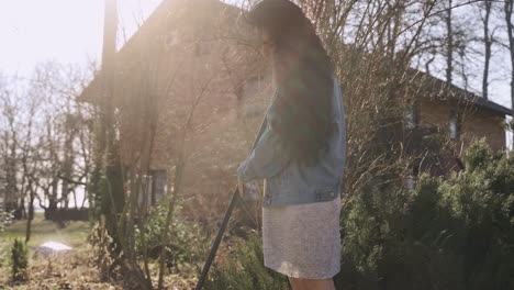 Caucasian-woman-removing-weeds-with-a-rake-in-the-countryside