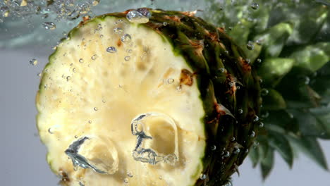 pineapple half floating in water on white background