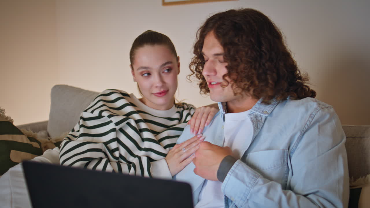 Romantic couple video calling by laptop sitting cozy living room sofa closeup