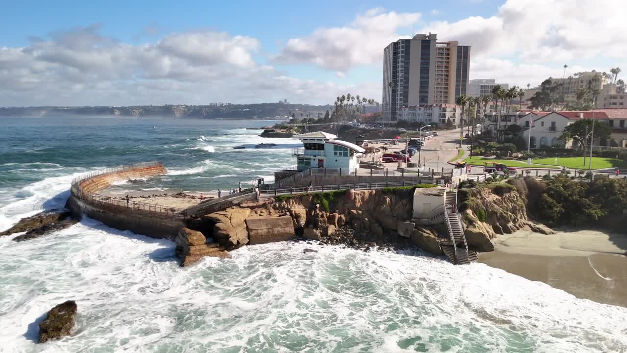 Sharp aerial footage highlighting the curved sea wall and surrounding rocks