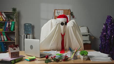 halloween businessman ghost in white sheet working at office standing and dancing in the room having