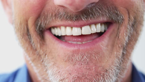 close up of mouth of mature man as he talks to camera in studio