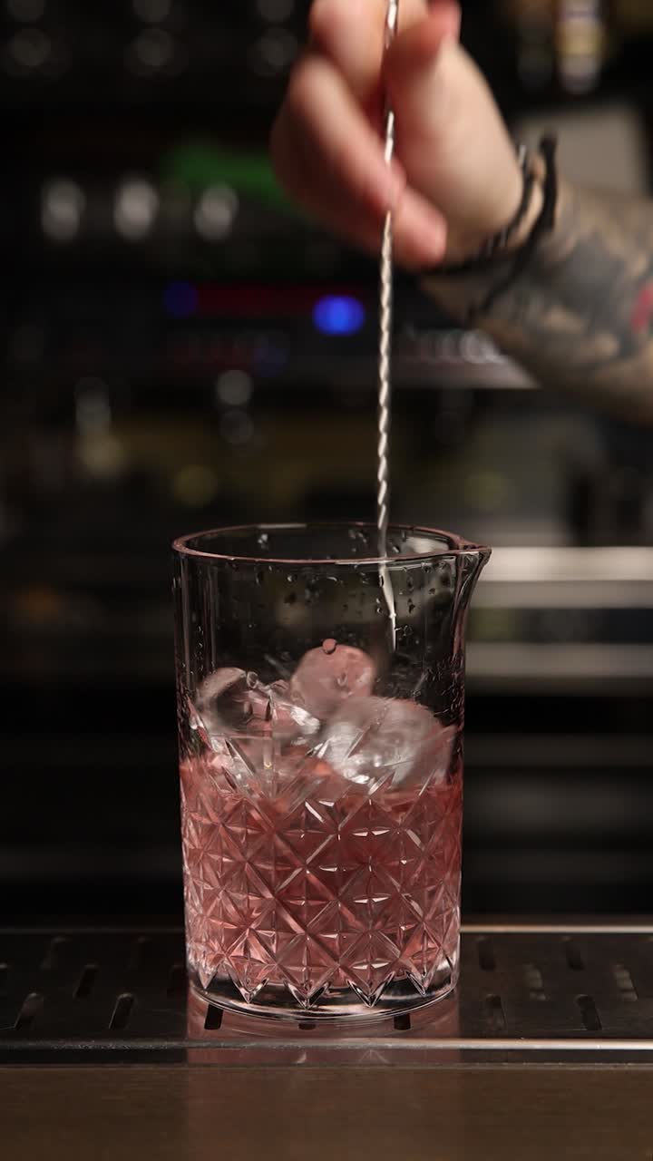Barman che mescola un cocktail rosa