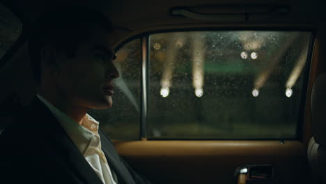 stylish businessman commuting automobile night town closeup. man looking window