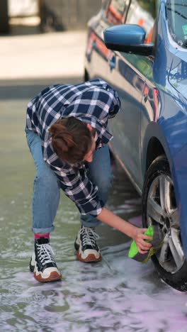 woman washing a blue car