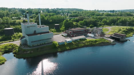 Aerial-Shot-Highlights-Hydroelectric-Power-Plant,-Dam,-and-Adjacent-Railroad-in-Rural-Maine