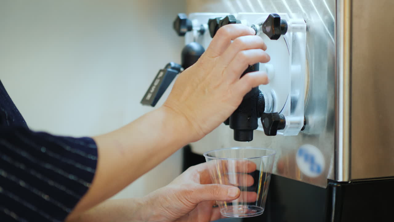 mujer vierte una bebida a base de hielo y vino en un vaso - corte
