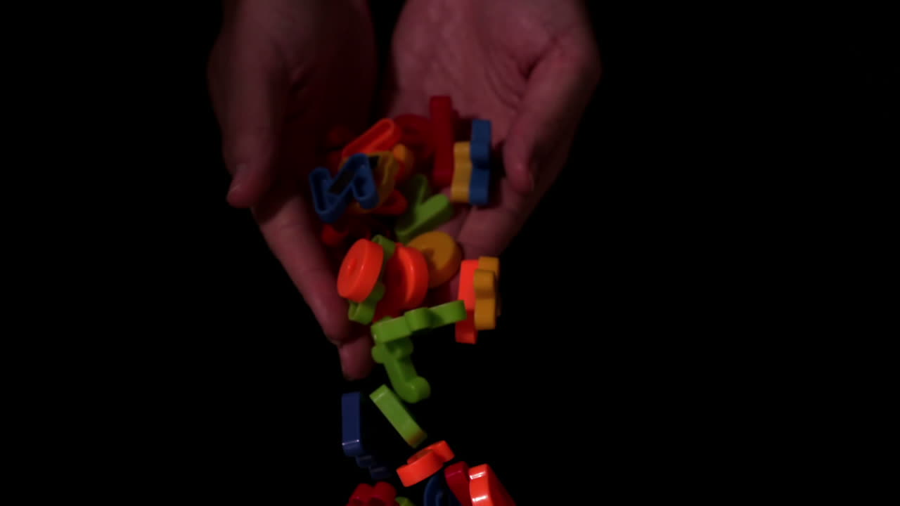 manos dejando caer imanes de letras del alfabeto