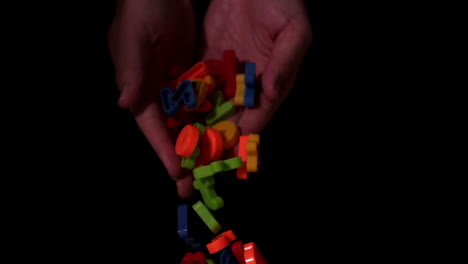 hands dropping alphabet letter magnets