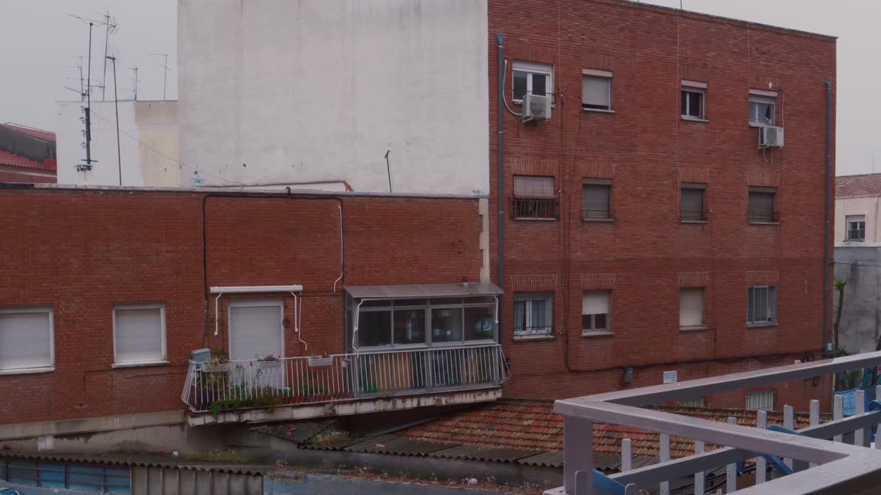 Vista exterior de edifícios residenciais de tijolos em uma área urbana.
