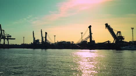 Aerial-view-of-camera-approaching-the-harbor-from-the-sea-side-in-the-glow-of-the-rising-sun