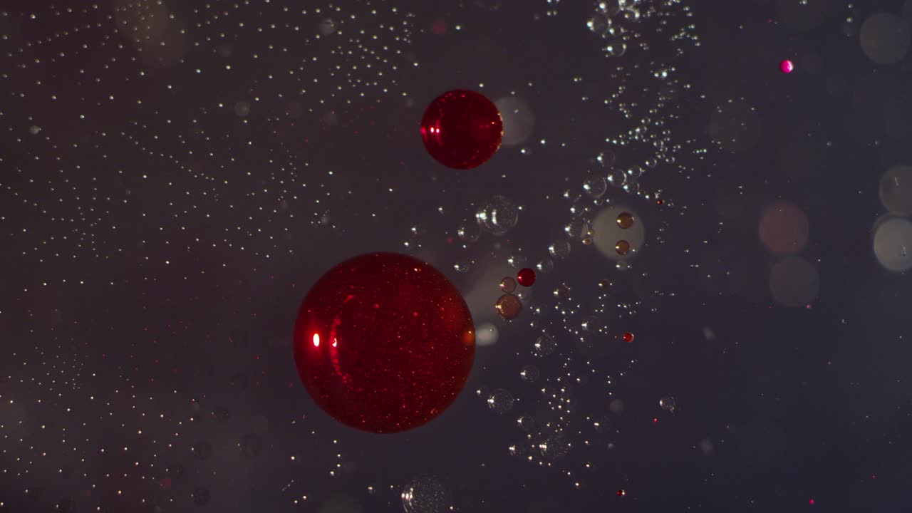 추상적인 빨간색과 은 액체 거품이 액체 보케 텍스처 배경에서 함께 움직입니다.