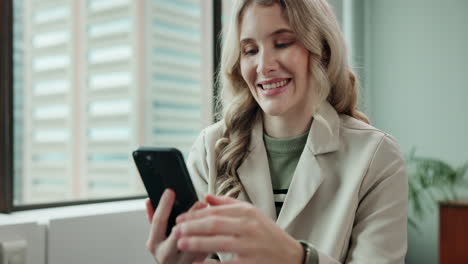 a smiling woman using her phone in an office