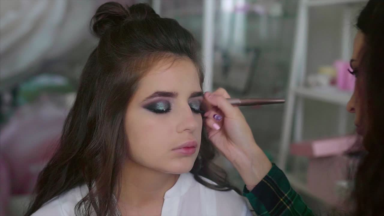 artista de maquillaje aplicando maquillaje a un modelo
