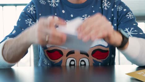 hombre en jersey de navidad poniendo carta para santa claus en sobre