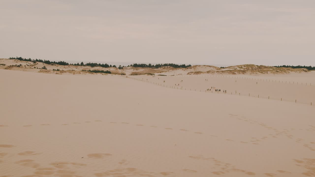 gente caminando sobre dunas de arena