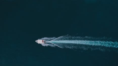 four boats speeding across dark blue