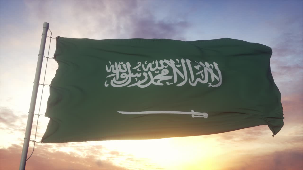 Saudi-Arabiens flag vajende i vinden mod en dyb smuk himmel ved solnedgang