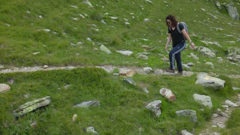 an active female hiker over trails in mountain hikes of alpe campagneda in valmalenco, lombardy, italy