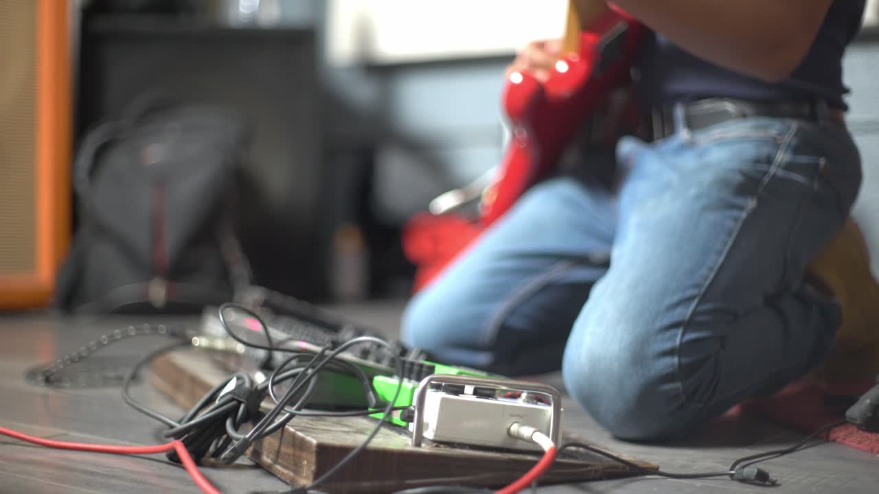 rockero configurando su guitarra eléctrica con equipo de ajuste, de mano