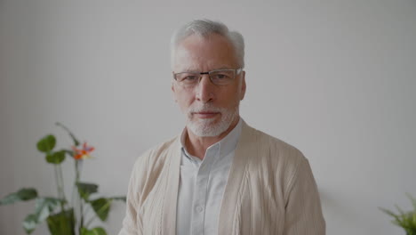 senior man looking serious at the camera while taking off his eyeglasses