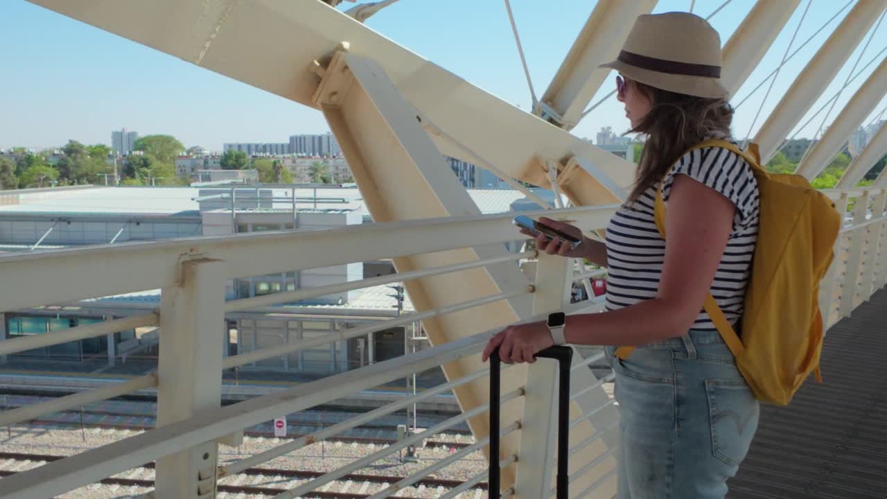 Woman Traveler on a Bridge Over Train Tracks