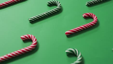 Red-and-green-striped-candy-canes-on-green-background