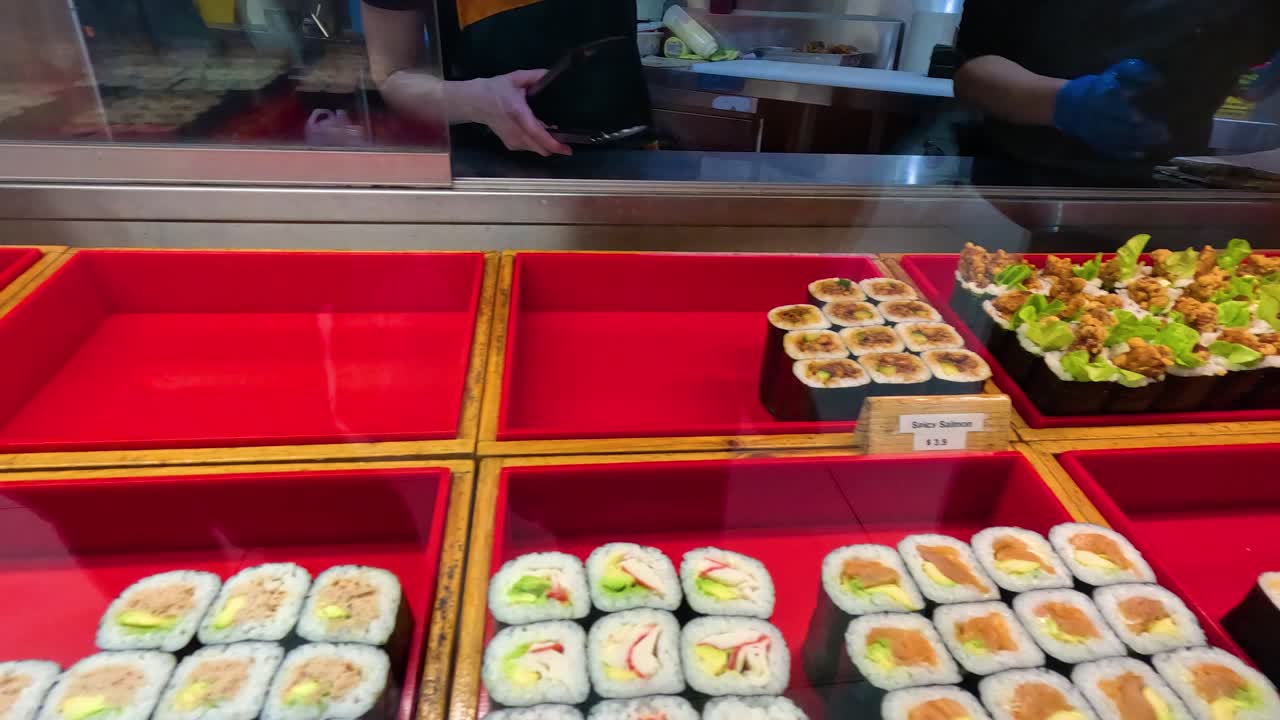 A vibrant sushi display in a Melbourne eatery showcases assorted rolls and dishes under bright lighting, highlighting culinary artistry